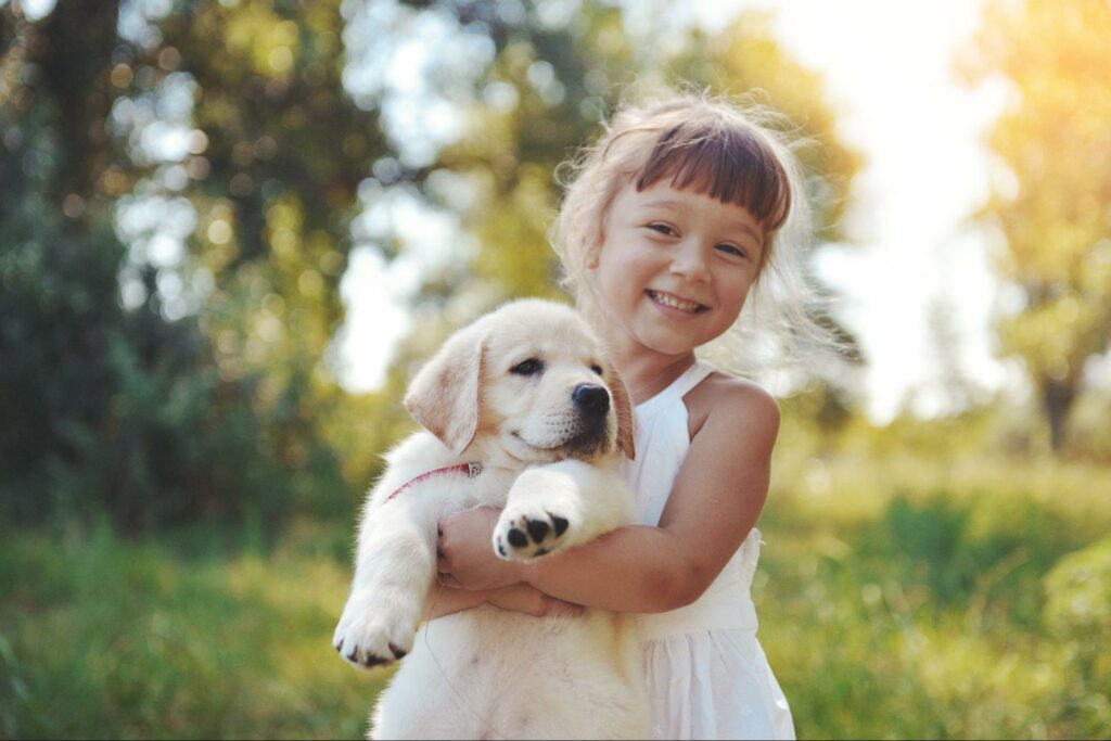 a girl holds her new puppy in the back yard