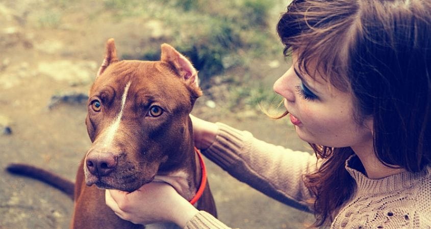 A woman gives her pup some love after a walk.